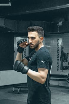 Adult male martial artist in a gym setting, showcasing readiness for training or competition.