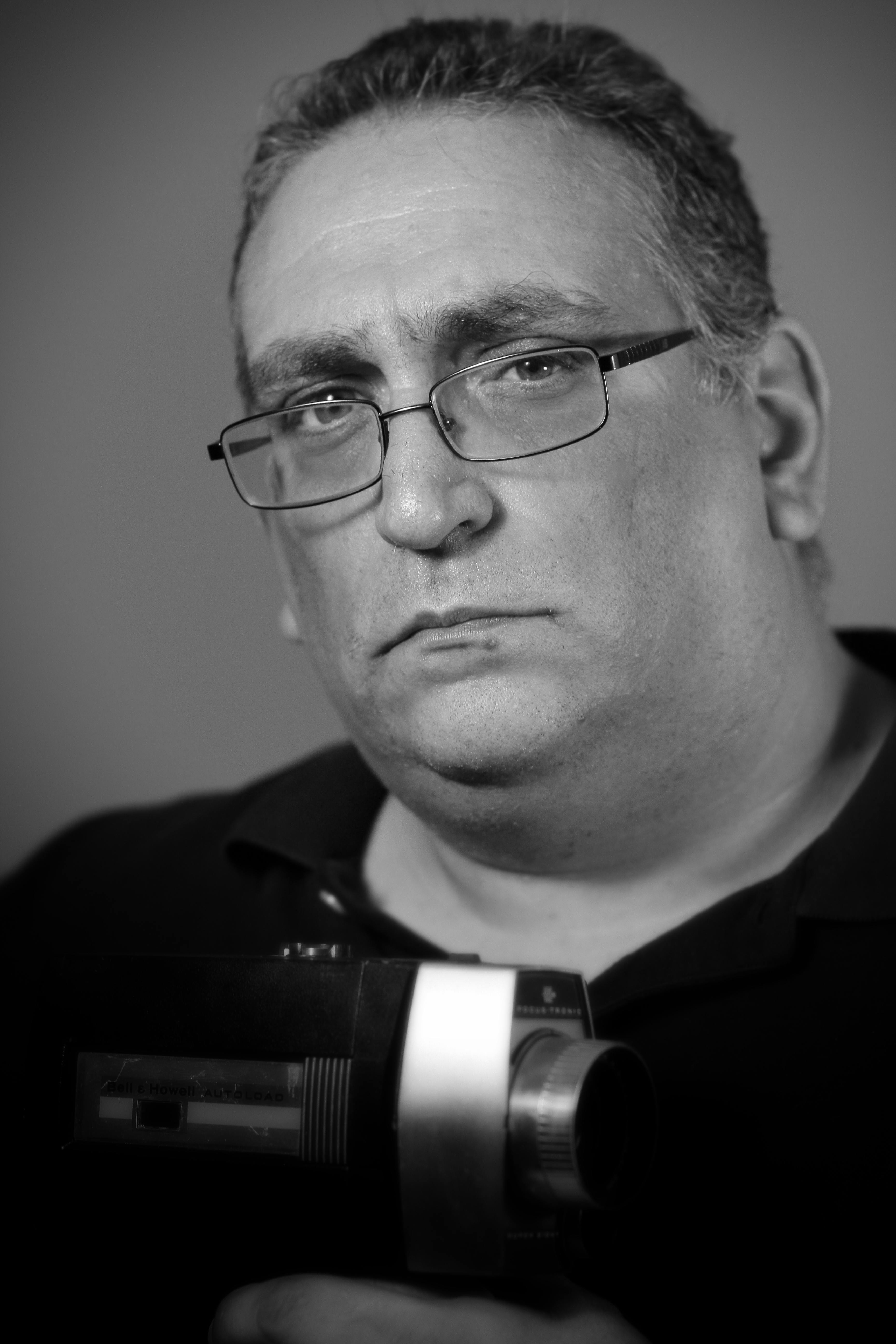 man in black framed eyeglasses holding a video camera