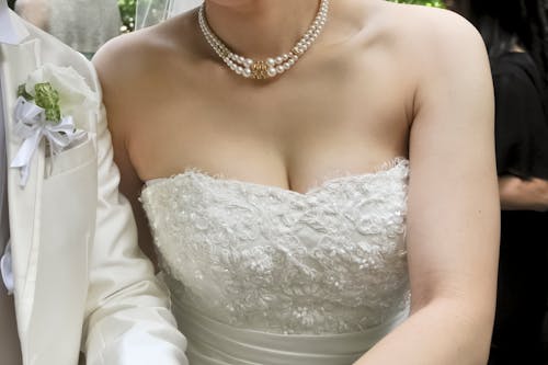 Free Close-up Photo of an Elegant Wedding Dress worn by a Bride  Stock Photo