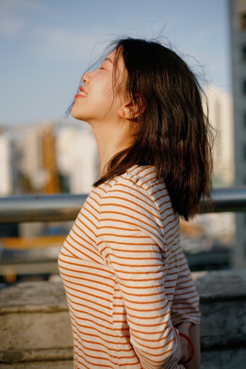 Asyalı kadın, çizgili gömlek, dikey atış içeren Ücretsiz stok fotoğraf