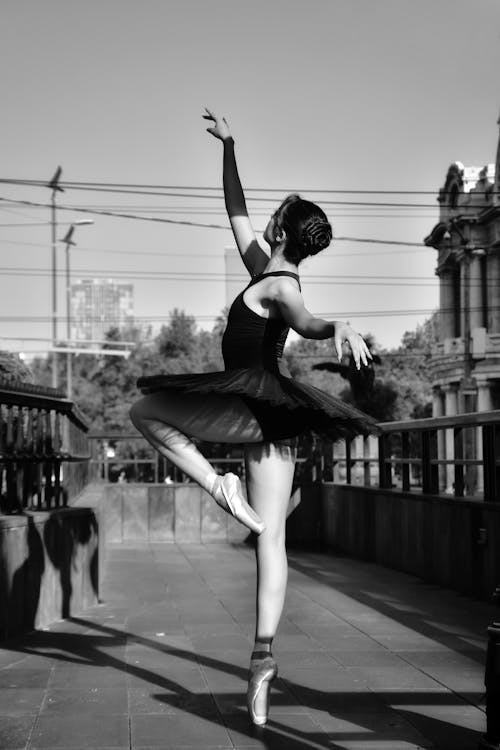 Grayscale Photo of a Woman Wearing Black Tutu while Dancing
