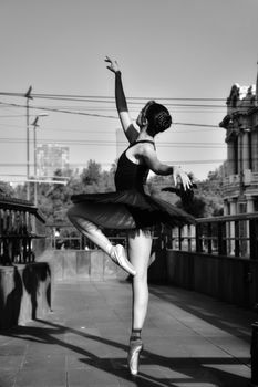 Graceful ballet dancer performing en pointe in a monochrome outdoor setting in Mexico City.