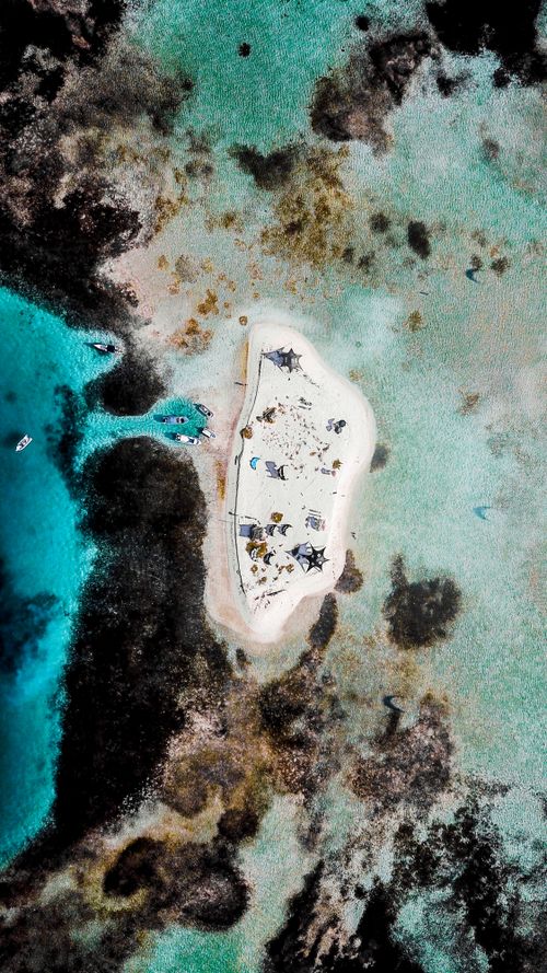 Free Stunning aerial photograph capturing a small tropical island surrounded by clear turquoise waters in Venezuela. Stock Photo