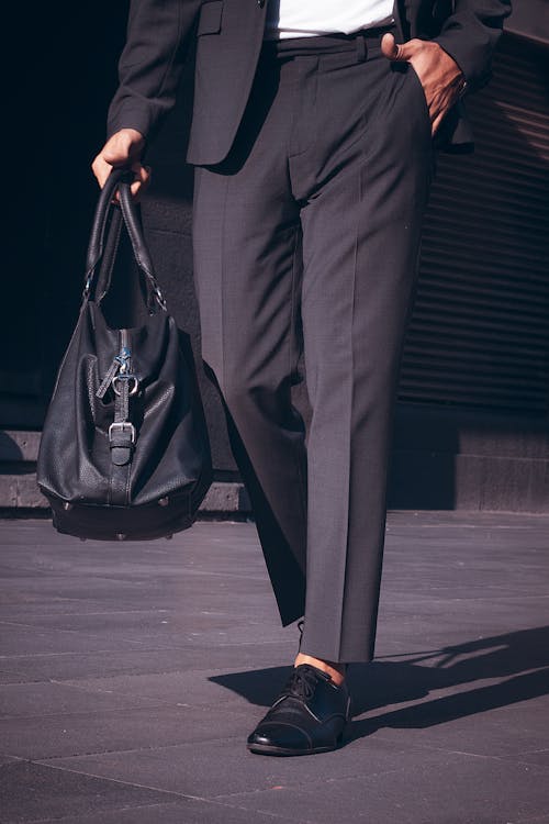 A Person Wearing Black Pants Carrying a Duffle Bag · Free Stock Photo