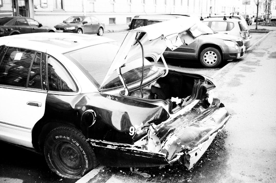 Kostenlos Graustufenfoto Des Zerstörten Autos, Das Außerhalb Geparkt Wird Stock-Foto