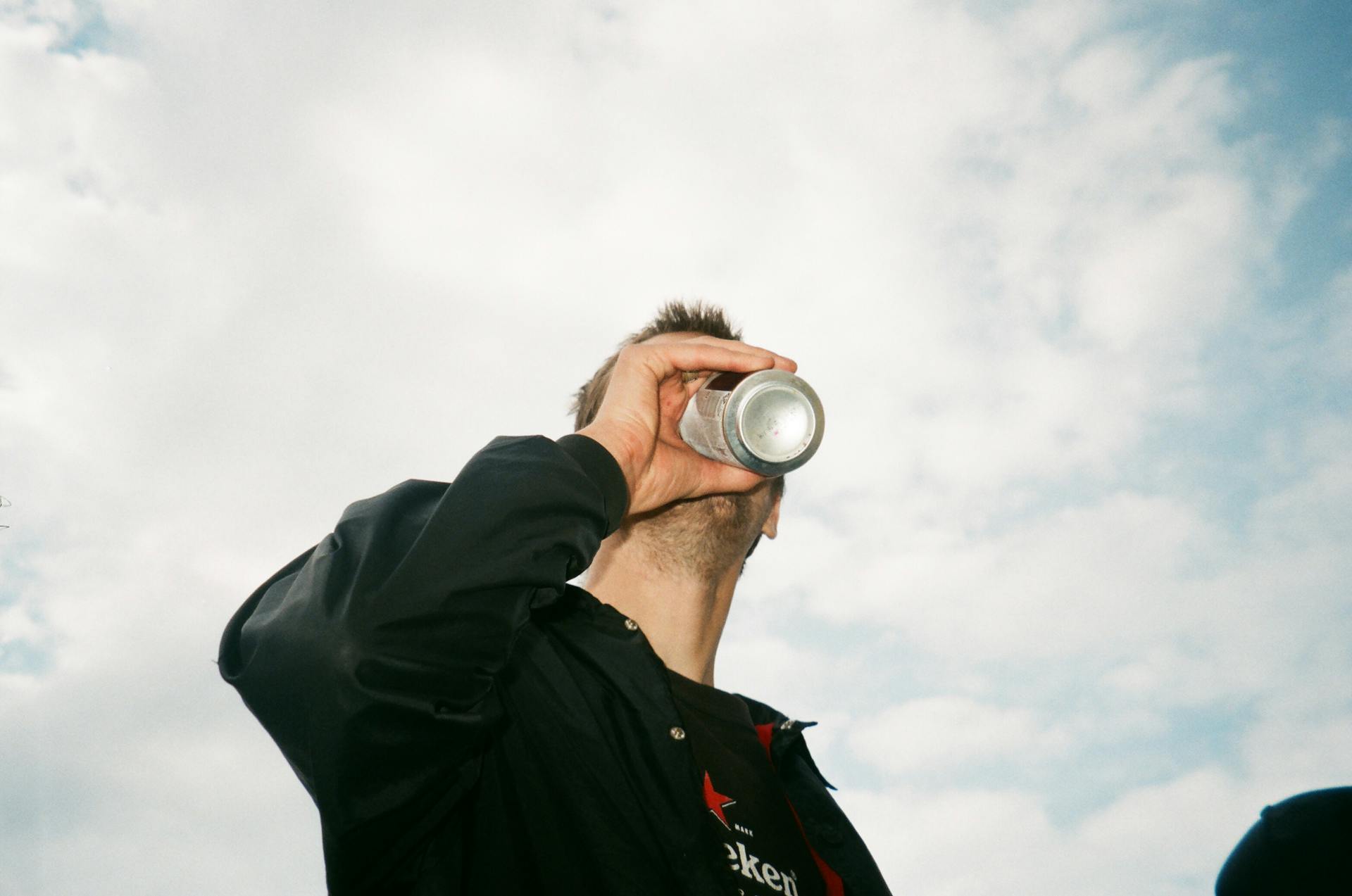 Low Angle Photography of Man Drinking Gray Labeled Can