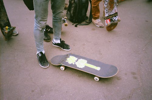 Person Standing Beside Broken Skateboard