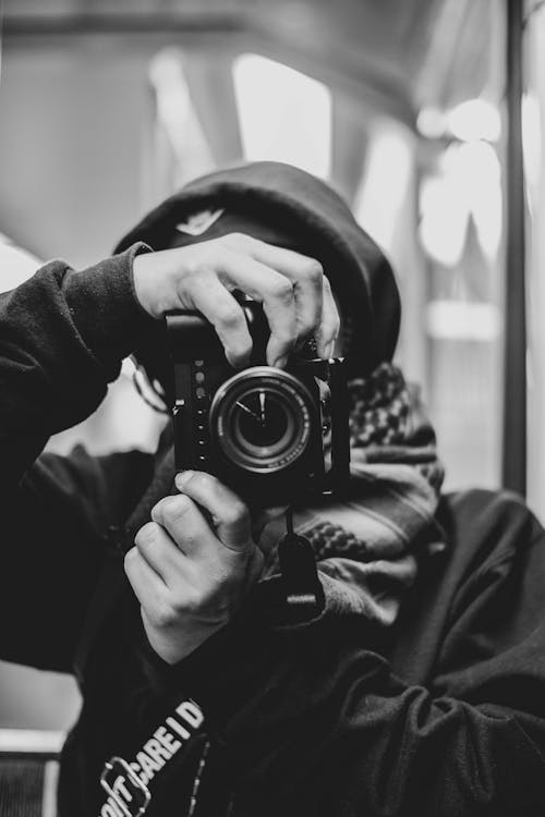 Free Grayscale Photo of Person Holding Camera Stock Photo