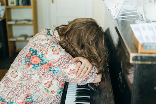 Close-up Photo of Woman sleeping on Piano 