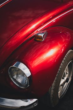 Artistic close-up of a vintage red Volkswagen Beetle fender, showcasing its classic design.