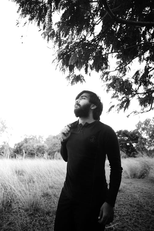 Monochrome Photo of Man standing underneath a Tree 