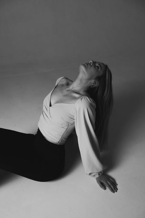 Free Grayscale Photo of Woman Sitting on the Floor While Looking Up  Stock Photo