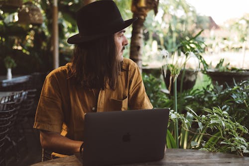 Man with a Laptop Computer at a Garden Table