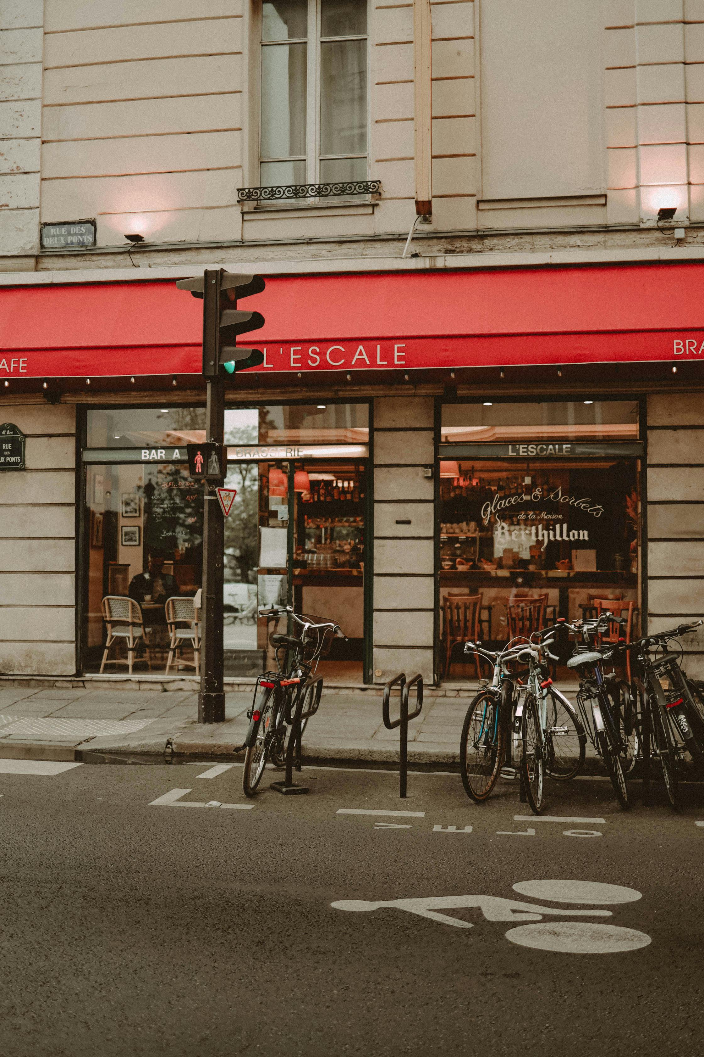 A quaint Parisian café with bicycles parked on a lively city street, exuding a vintage feel.