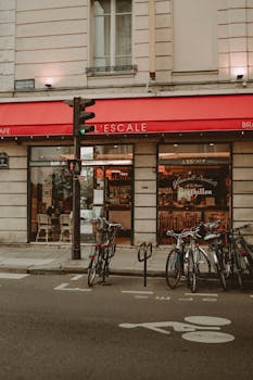 A quaint Parisian café with bicycles parked on a lively city street, exuding a vintage feel.