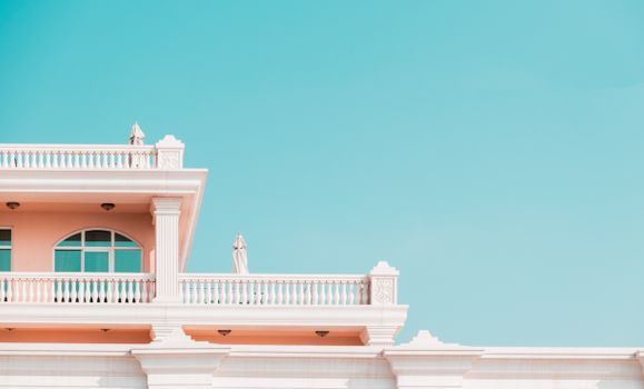 Traditional building facade with balconies against a clear blue sky, showcasing classic architectural design.