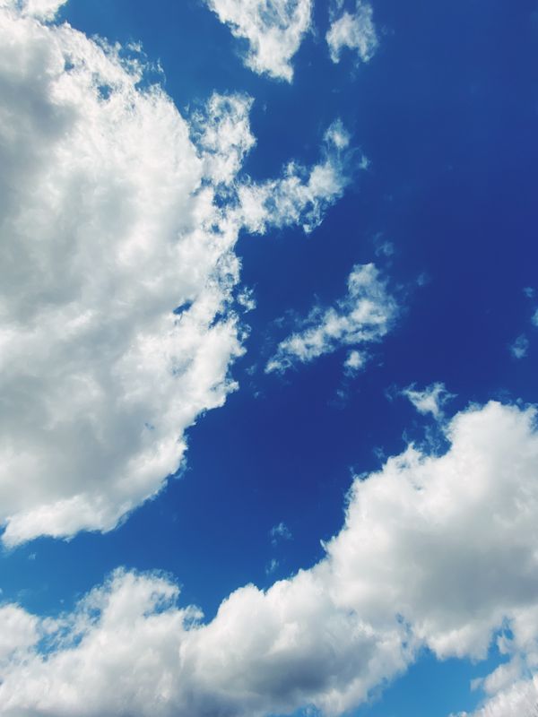 Vista impressionante de um céu azul brilhante preenchido com nuvens fofas, simbolizando paz e tranquilidade.