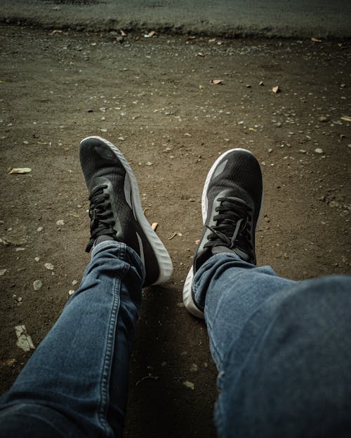 Person in Blue Denim Jeans and Black Sneakers 