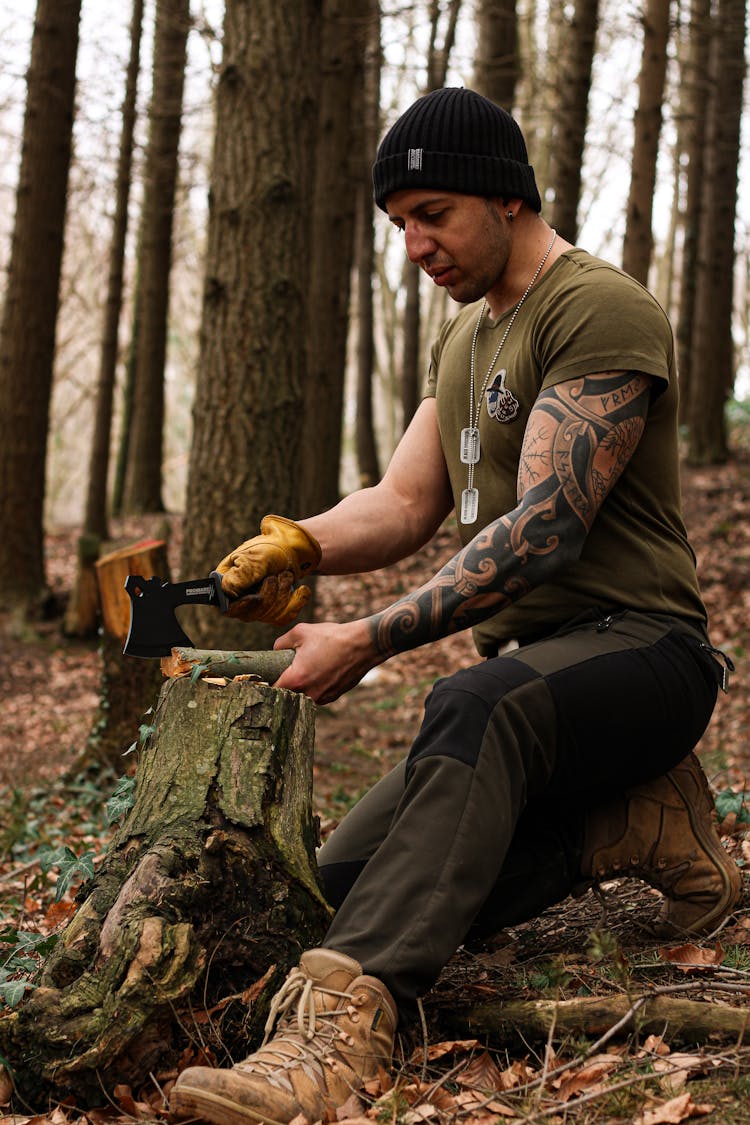 Man Chopping Wood With An Axe In A Forest 