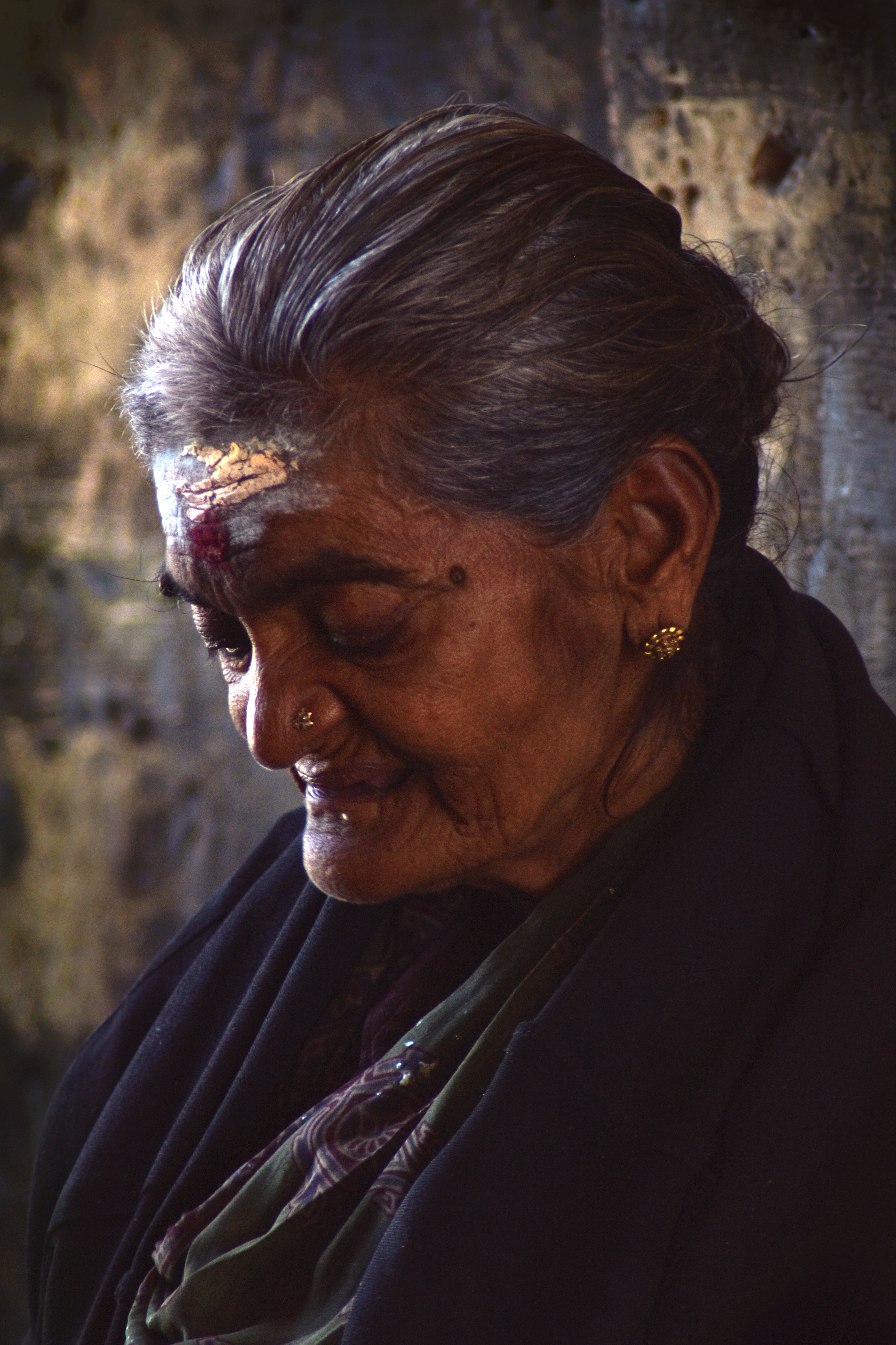 Close-up portrait of a smiling elderly woman with traditional markings on her forehead, Sri Lanka.