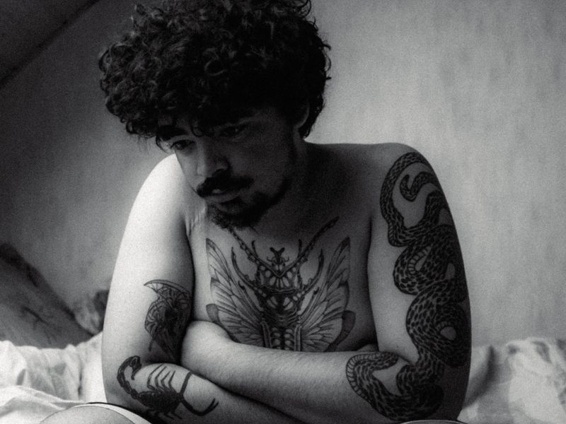 Black and white portrait of tattooed resident artist Dario Lim