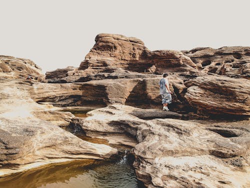 Person Standing on Brown Rocks