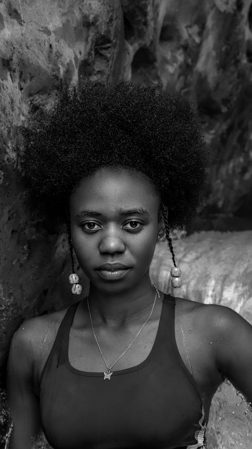 Free Striking black and white portrait of a woman with natural afro hair, conveying a serious expression. Stock Photo