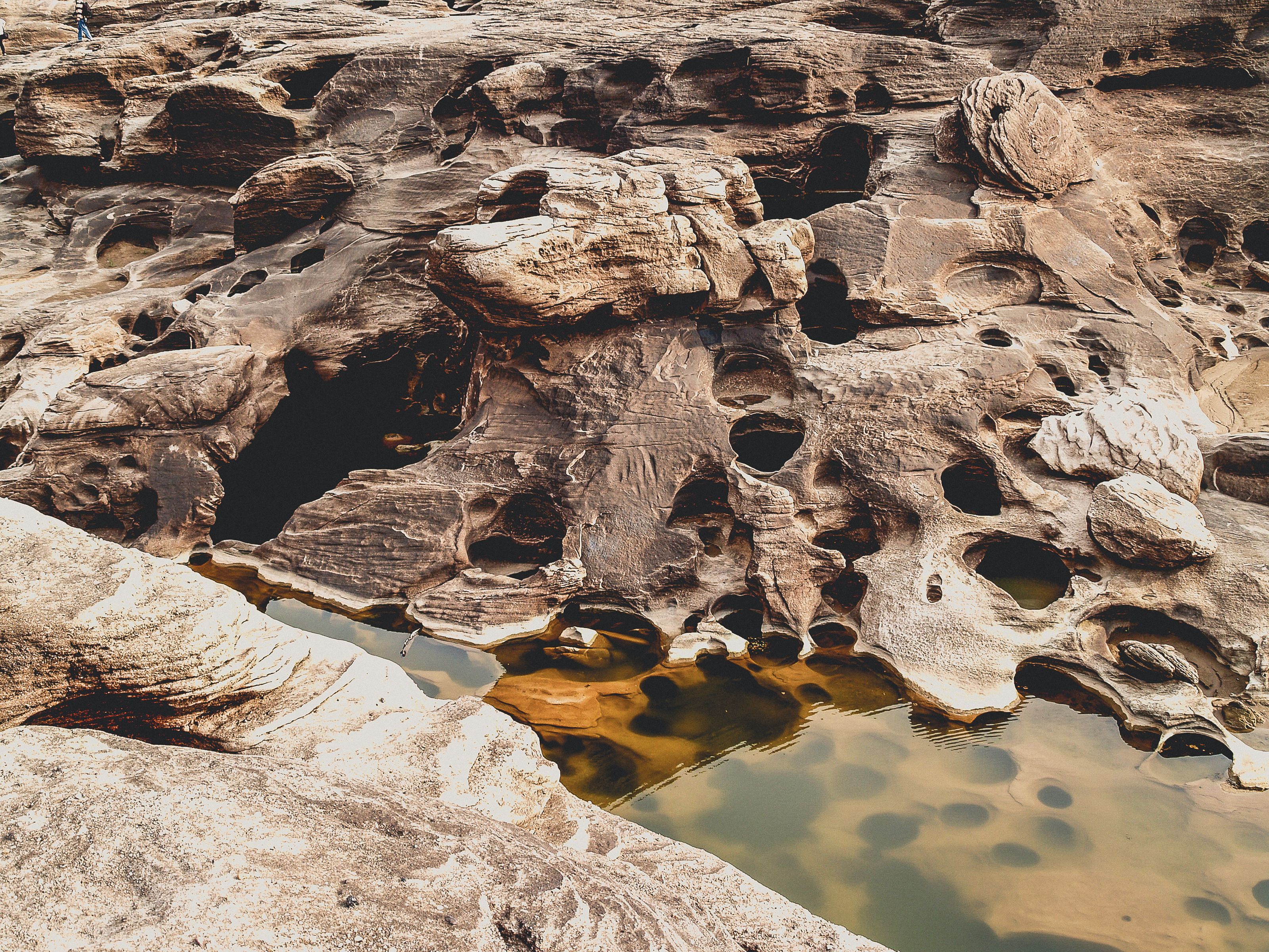 Close-up Photo of Brown rocks Beside Body of Water · Free Stock Photo