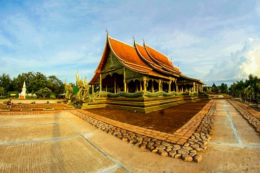 Stunning view of a traditional Buddhist temple with elaborate carvings and vibrant colors under a clear sky.