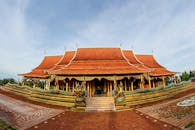 这座令人惊叹的佛教寺庙拥有红色屋顶和金色装饰，坐落于宁静的公园环境中