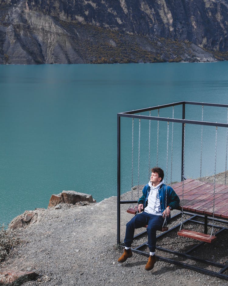 A Man Sitting On The Swing 