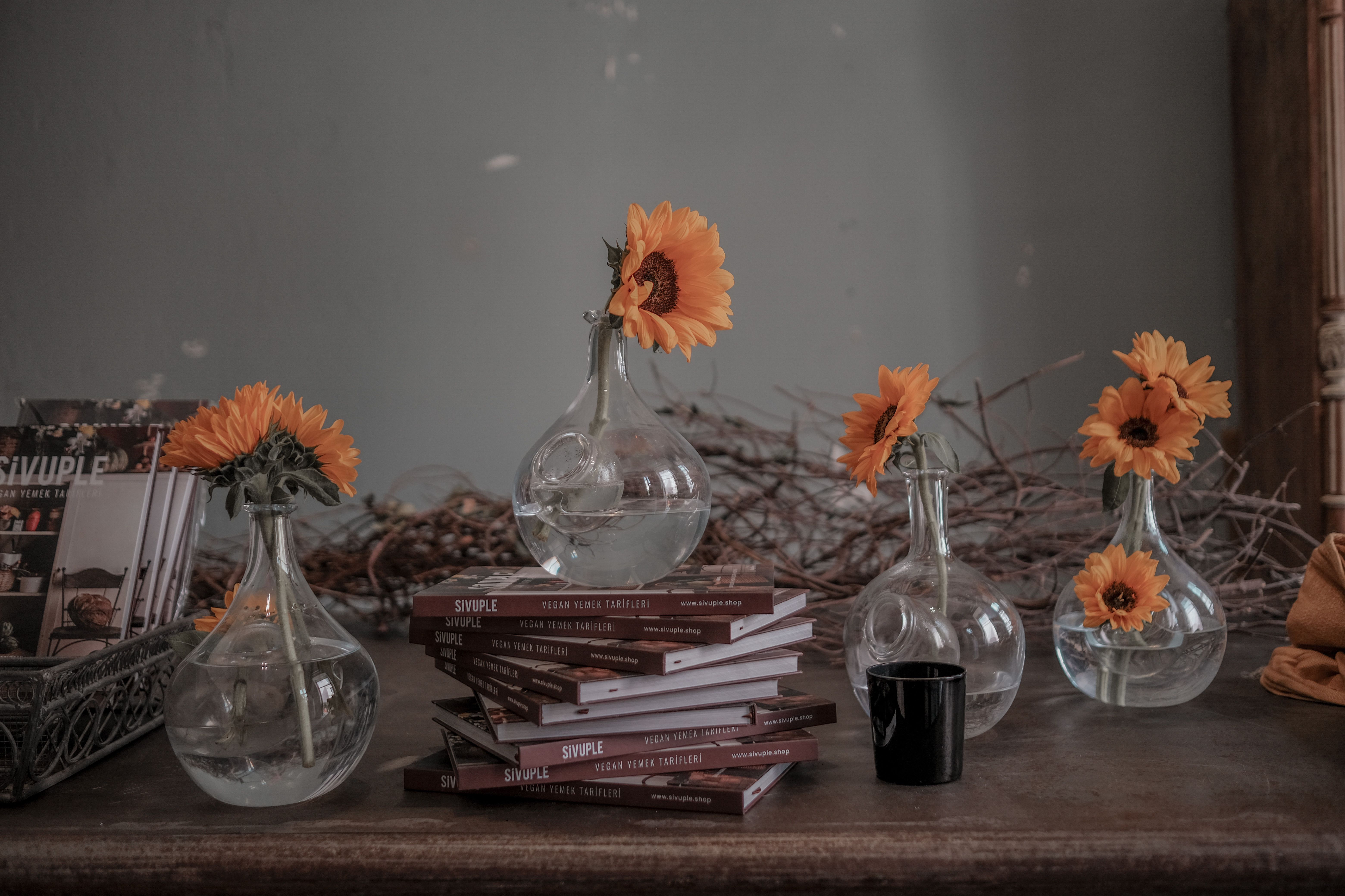 Aesthetic arrangement of sunflowers and books on a rustic wooden table, perfect for cozy decor inspiration.