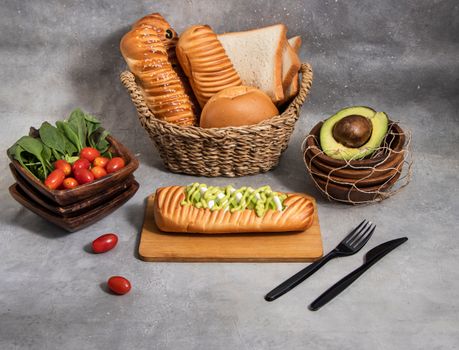 A fresh and appetizing arrangement of breads, avocado, and cherry tomatoes on a minimalist background.