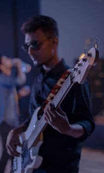 Musician playing bass guitar on stage during a live performance, capturing the essence of a vibrant concert.