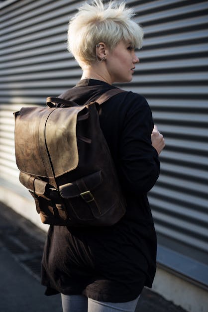 Woman Carrying Brown Leather Backpack Posing in Front of Roll-up Door ...