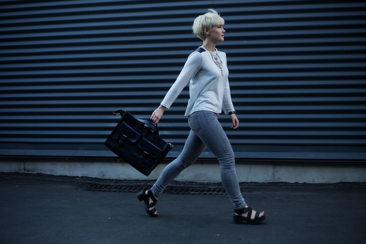 Woman carrying a black leather handbag on the street