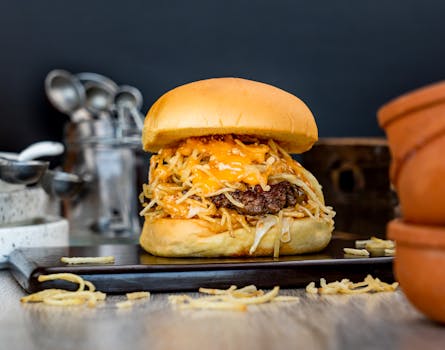 Tasty cheeseburger with melted cheese and crispy onions on a wooden platter.