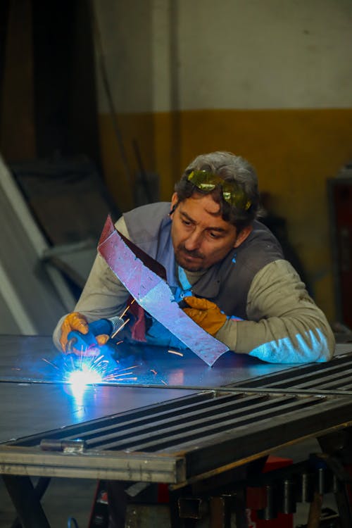 Photo of a Man Welding Metal 