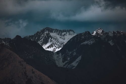 Free Snow Covered Mountain Under Dark Cloudy Sky Stock Photo