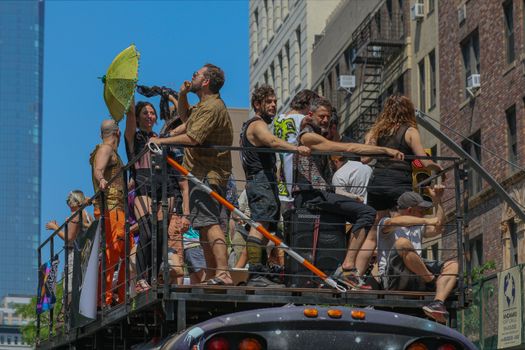 People on Top of A Bus in a Motorcade