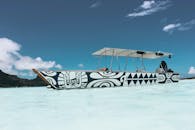 在法属波利尼西亚瓦伊塔普岛清澈的水面上，漂浮着装饰有部落图案的彩色船