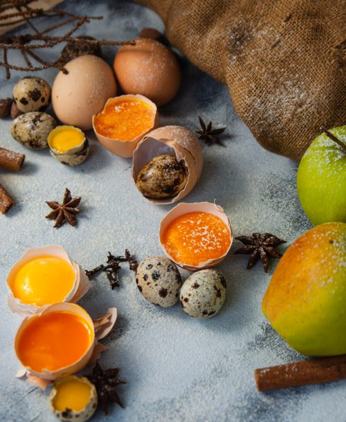 Free A rustic still life featuring eggs, fruits, and spices in a cozy setting. Stock Photo