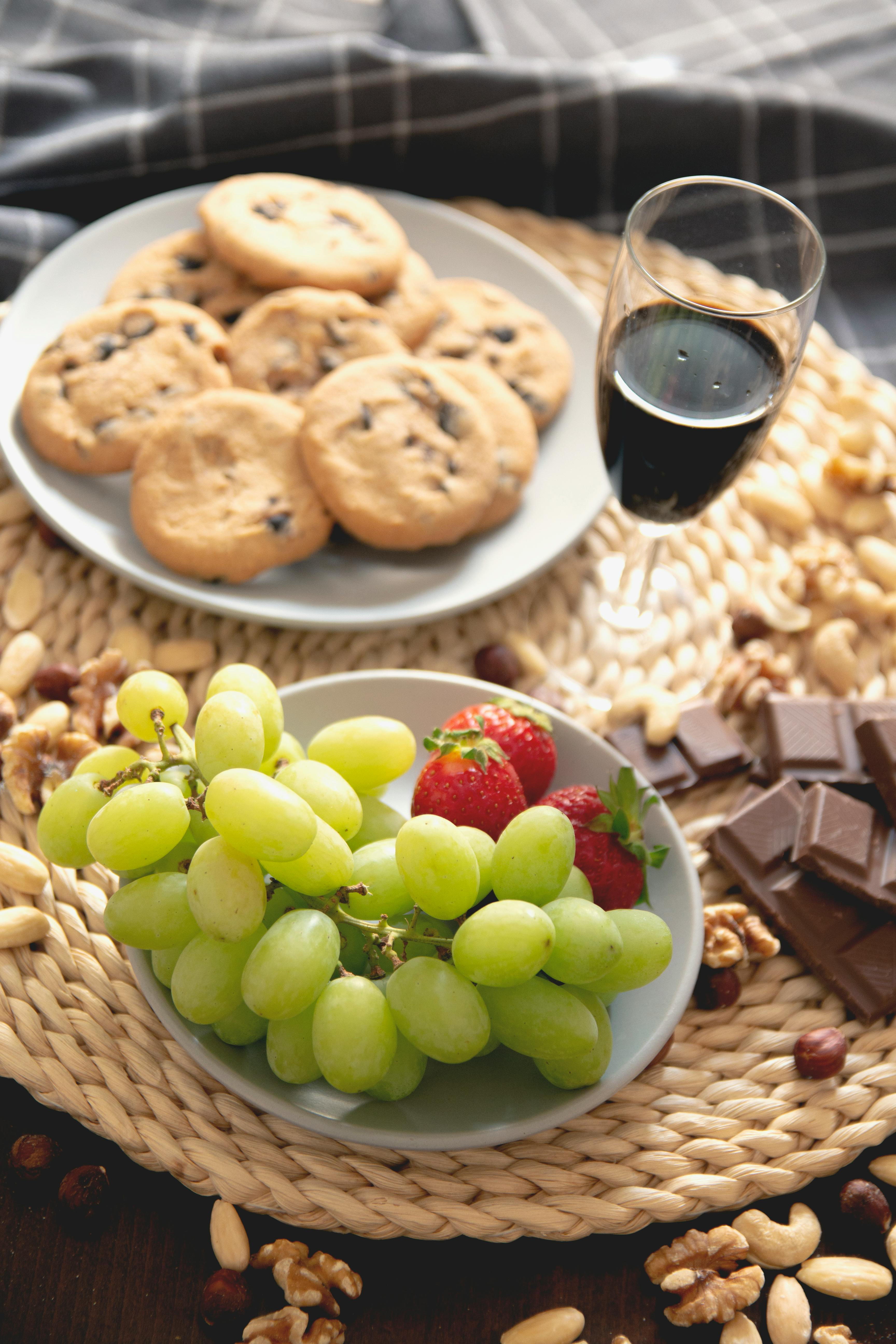 A delectable spread of cookies, fruits, nuts, and wine perfect for indulgence and relaxation.