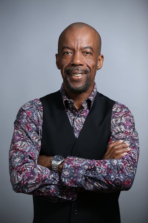 Portrait of a Man in a Black Vest Posing with His Arms Crossed