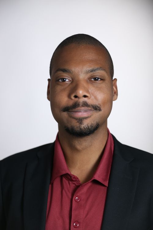 Free Portrait of a confident man in formal attire looking serious against a plain background. Stock Photo