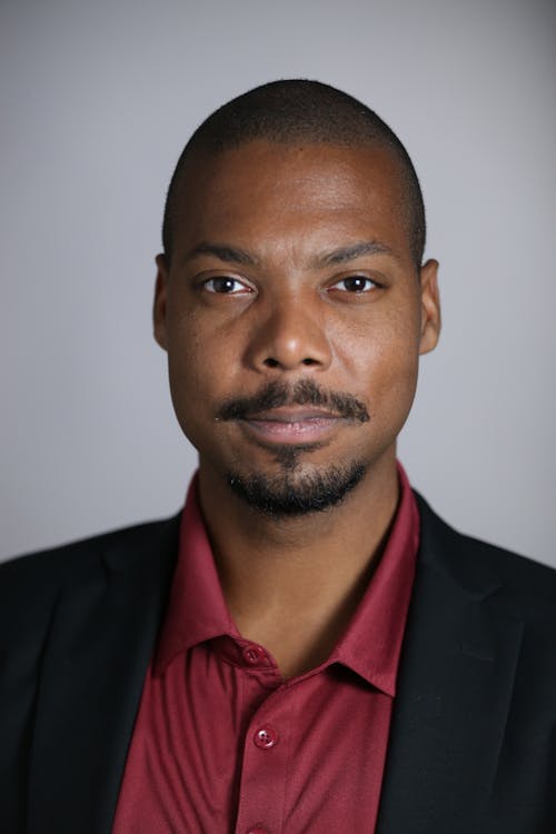 Man Wearing Black Suit on Gray Background