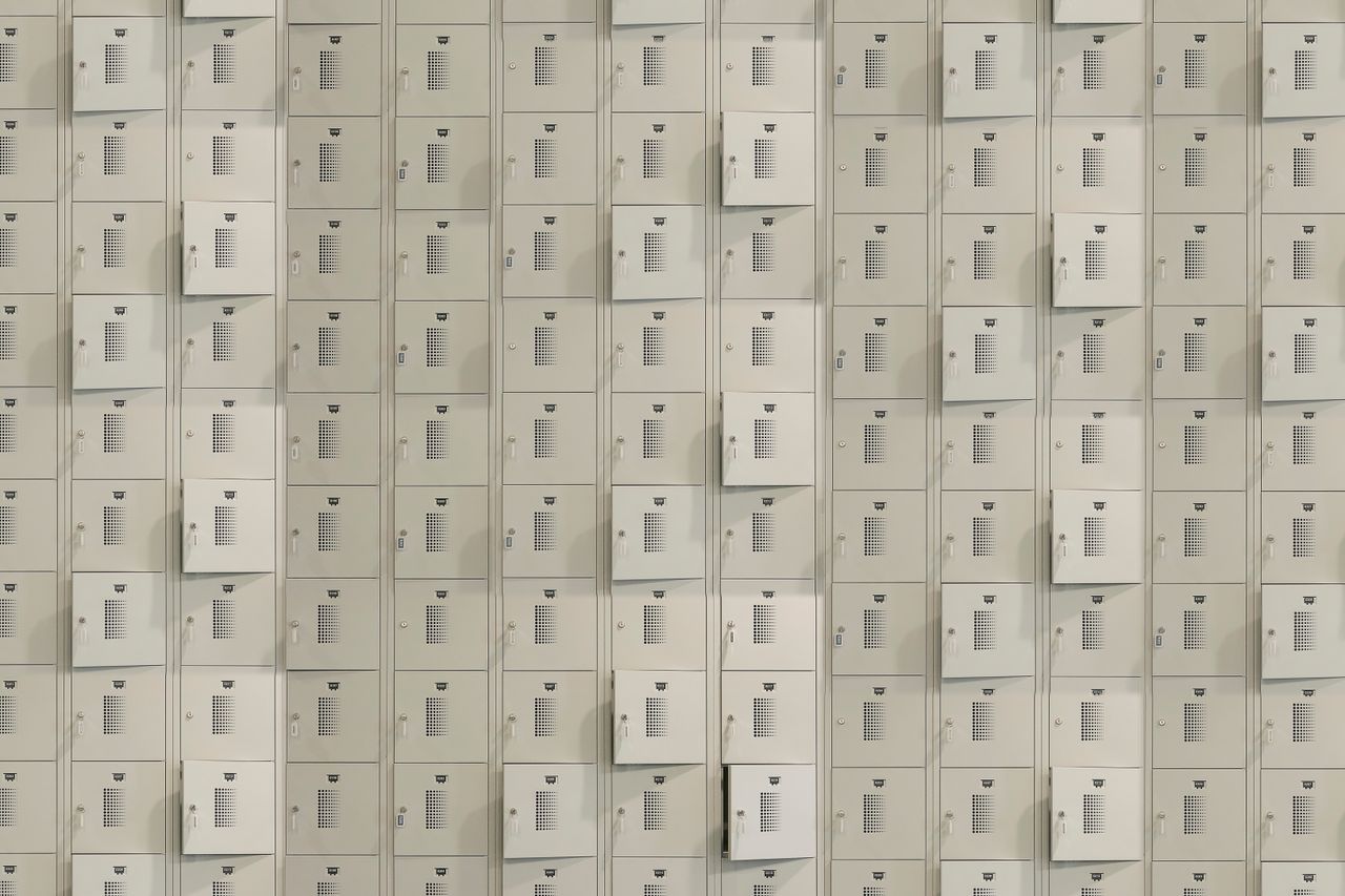 a uniform array of metal storage lockers with some doors slightly ajar