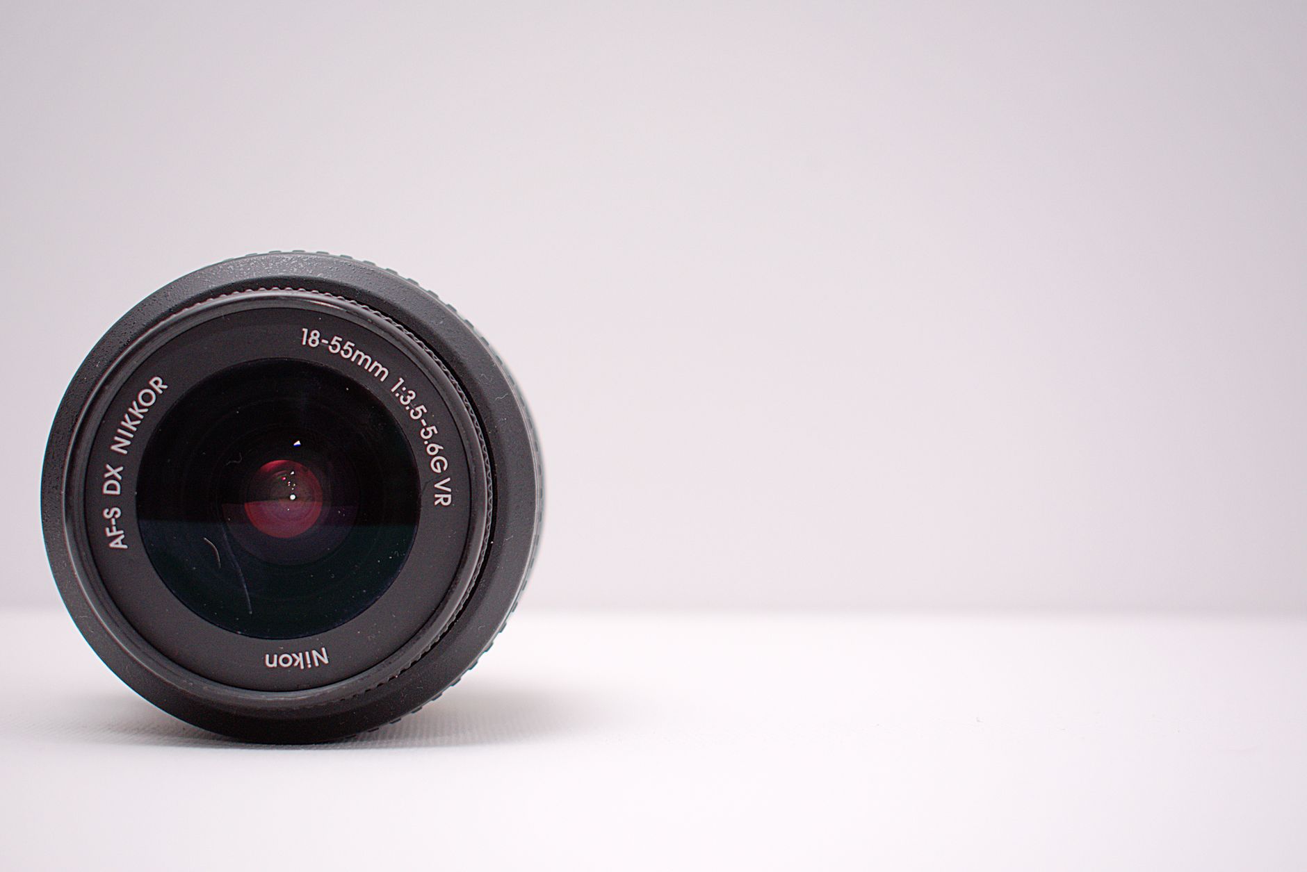 Detailed close-up shot of a Nikon AF-S DX NIKKOR lens on a white background.
