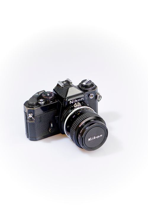 Free Close-up of a classic Nikon camera displayed on a white surface for a gadget-themed visual. Stock Photo