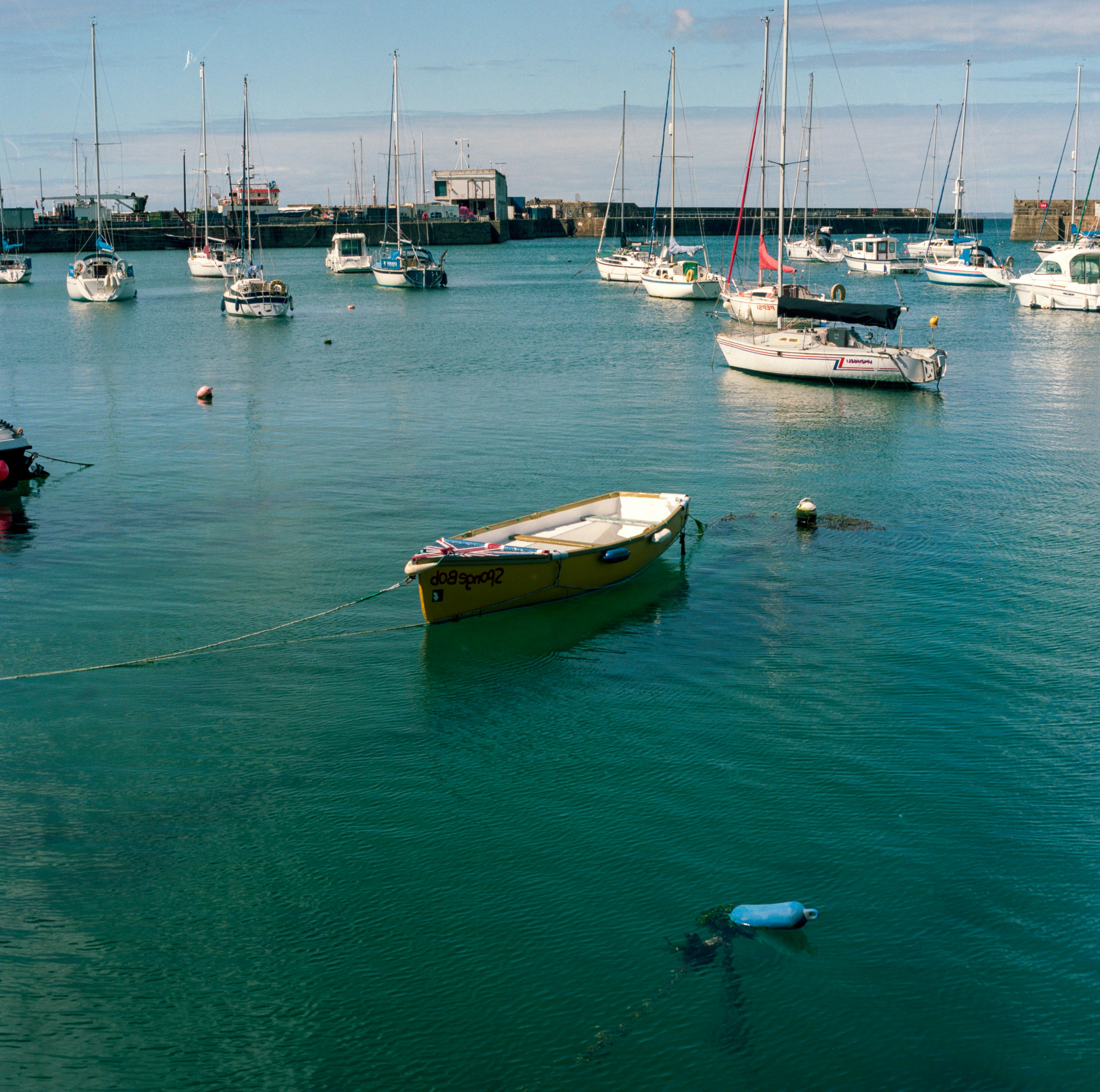 A peaceful scene of boats moored in a serene harbor under a clear sky.